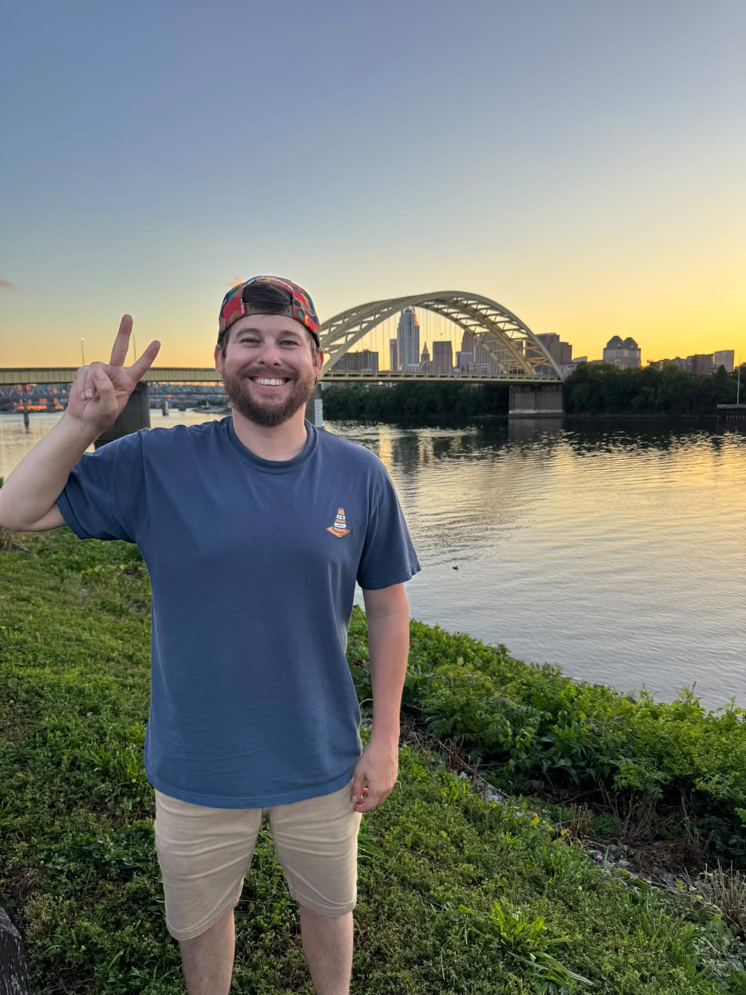 Andrew Isler smiling by the river at sunset